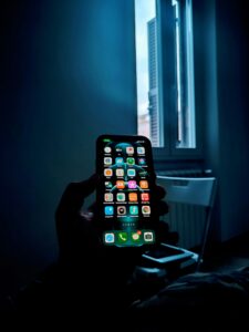 “Anonymous person holding a smartphone, symbolizing loss of privacy after nonconsensual intimate images are shared online”