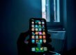 “Anonymous person holding a smartphone, symbolizing loss of privacy after nonconsensual intimate images are shared online”