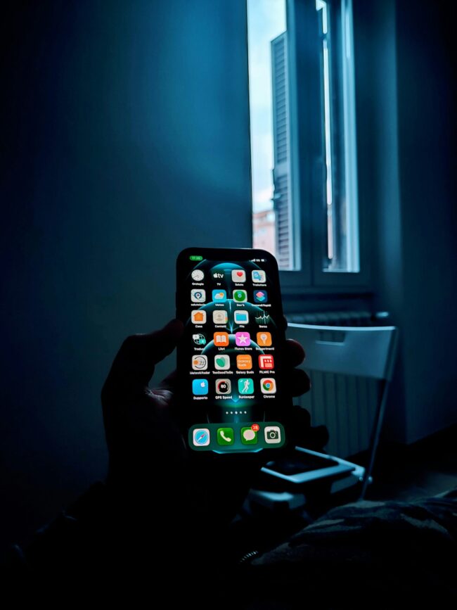 “Anonymous person holding a smartphone, symbolizing loss of privacy after nonconsensual intimate images are shared online”